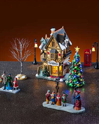 Scène de Noël Lemax avec magasin, sapin illuminé et figurines.